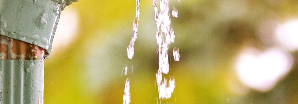 turn key gutters Close up shot of cracked gutters with water pouring out of them.