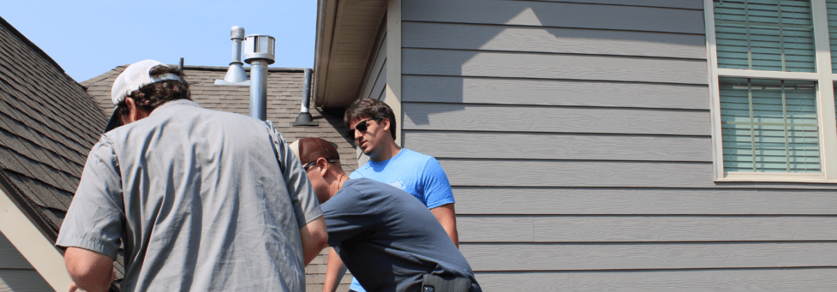 Turn Key Roof Inspection Three Turn Key Roofing employees on roof, inspecting it thoroughly.
