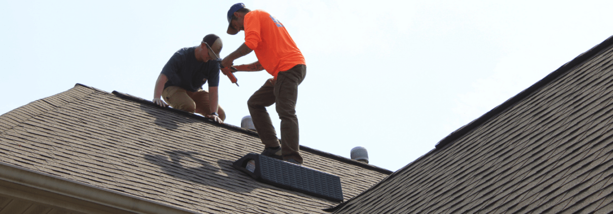 Turn Key Warranty Two male Turn Key Roofing Employees on top of residential roof.