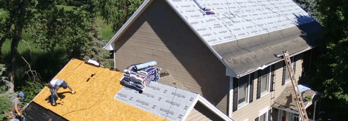 Turn Key How Tree Coverage Impacts Your Roof in South Carolina Roofing contractors working on residential roof surrounded by trees.